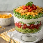 Classic seven layer salad with fresh layers of lettuce, peas, eggs, bacon, and cheese